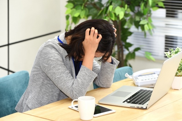 悩んで頭を抱える女性